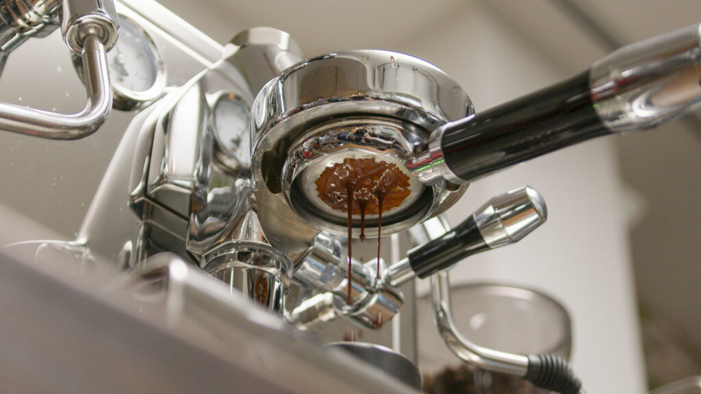 Durch den Siebträger fliesst der extrahierte Espresso